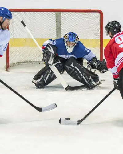 Three People Playing Ice Hockey